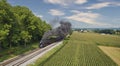 Drone View of an Antique Steam Engine, Approaching, Blowing Steam and Traveling Along the Countryside Royalty Free Stock Photo