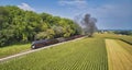 Drone View of an Antique Steam Engine, Approaching, Blowing Steam and Traveling Along the Countryside Royalty Free Stock Photo