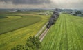 Drone View of an Antique Steam Engine, Approaching, Blowing Steam and Traveling Along the Countryside on a Sunny Day Royalty Free Stock Photo