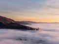 Drone view of Assisi Umbria Italy above a sea of fog at sunset