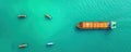 Drone view of a cargo ship surrounded by smaller support vessels Royalty Free Stock Photo
