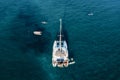 Drone view of Catamaran anchored in blue sea with swimming people in summer. Travel background. Royalty Free Stock Photo