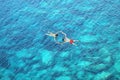 Drone view of couple snorkeling in clear blue sea water Royalty Free Stock Photo