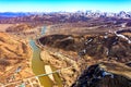 Drone view of dried-up riverbed in mountains. Yellow grass and big rocks. A steep gorge with an ascent to a mountain Royalty Free Stock Photo