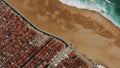 Drone view of emerald ocean washing amber beach by town Royalty Free Stock Photo