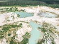 Drone view on a flooded kaolin quarry with turquoise water and white shore. Aerial shot of a kaolin pit flooded with water