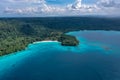 Drone view of green shore near turquoise sea under blue clouds. Tropical paradise. Sanma, Vanuatu