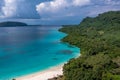 Drone view of green shore near turquoise sea under blue clouds. Tropical paradise. Sanma, Vanuatu