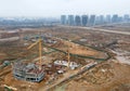 Drone view of a large construction site. Tower cranes in action on fog background. Housing renovation concept. Crane during Royalty Free Stock Photo