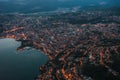 High angle aerial drone shot view Lugano by lake with city street lights after sunset in Switzerland