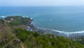 Drone view of Menganti Beach, Kebumen, Indonesia, beautiful beach with white sand, calm waves, coral cliffs and green trees