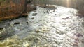 Drone view moving slowly over the rapids of the river in Brownsburgh-Chatham, with the refelction of the sun in the water