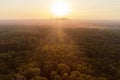 Drone view over forest and trees and an industrial area during the sunset in the ruhr area in Germany