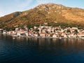 Drone view of Perast at the foot of the mountains in the rays of the setting sun. Montenegro