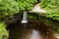 Drone view of a waterfall and pool in a narrow canyon and green forest Sgwd Gwladys, Brecon Beacons, Wales
