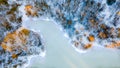 Drone view of a river with an icy lake on a snowy forest plain during a clear winter morning and bright sunrise Royalty Free Stock Photo