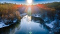 Drone view of a river with a lake on a snowy forest plain during a clear winter morning and bright sunrise Royalty Free Stock Photo