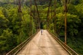 Drone view of senior woman walking dog across Jenkinsburg Bridge over Cheat River Royalty Free Stock Photo