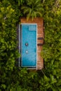 drone view of a swimming pool in the jungle , couple men and women in a pool in the rainforest