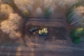 Drone view of a tractor that works on landscaping harvesting the branches of felled trees. Generative AI