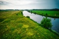 Drone view of the Vecht river, green grass, blue water, city with high voltage poles. Vechtdal, Dalfsen the Netherlands