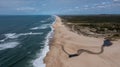 Drone view of a wide endless golden sand beach with a river flowing to the ocean