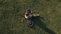 Drone view woman cyclist lying on green grass and using mobile phone Royalty Free Stock Photo