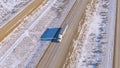 DRONE: White truck hauls cargo down scenic freeway running across snowy desert