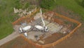 DRONE: Workers pouring concrete from a truck, creating the house foundation.