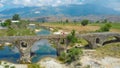 DRONE Young woman in red dress walks along the ancient ottoman bridge in Albania