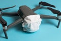 Drones forbidden concept: Unfolded drone covered by medical face mask