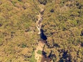 Drop down view of river runing through forest. Royalty Free Stock Photo