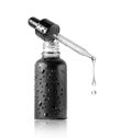 Drop dripping from a cosmetic pipette isolated on a white background. Black bottle with cosmetic oil close up Royalty Free Stock Photo