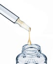 Drop falls from a cosmetic ampoule into a bottle close-up Royalty Free Stock Photo