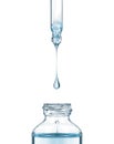 Drop falls from a pipette into a cosmetic bottle on white Royalty Free Stock Photo