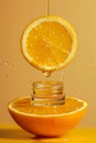 A drop of golden oil and serum flows down the orange into the bottle Royalty Free Stock Photo