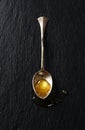 Drop of honey in a silver spoon Royalty Free Stock Photo