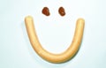 Drop of ketchup and long pork sausage stuffed cheese with ham look like smiling face on white background