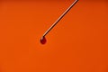 A drop of medicine on the tip of a medical injection needle. Red background Royalty Free Stock Photo