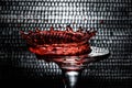 A drop of red wine in the form of a crown which fell on a glass goblet. Royalty Free Stock Photo