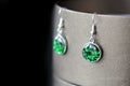 Drop resin earrings with green sparkles on a dark background Royalty Free Stock Photo