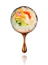 Drop of soy sauce drips from a sushi roll on white background