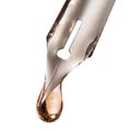 Drop of transparent liquid on nib of pen Royalty Free Stock Photo