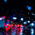 a drop of water drops on glass, wet and rain against an abstract background with colorful defocused lights Royalty Free Stock Photo