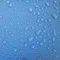 A drop of water on the hood of the car. Water beads after rain or car wash on blue paint surface. Royalty Free Stock Photo