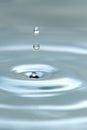 A drop of water hovering in the air before hitting a water surface, which will cause a beautiful splash, close-up photo Royalty Free Stock Photo