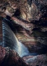 drop of waterfall in canyon narrow and dark background vertical gorge