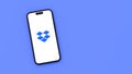 Dropbox Logo on Mobile Phone Screen on Blue Background with Copy Space