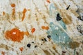 Orange cyan brown black white paint stain on a dropcloth