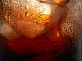 Droplets on the wall of a glass of cola with ice cubes. Macro shot Royalty Free Stock Photo